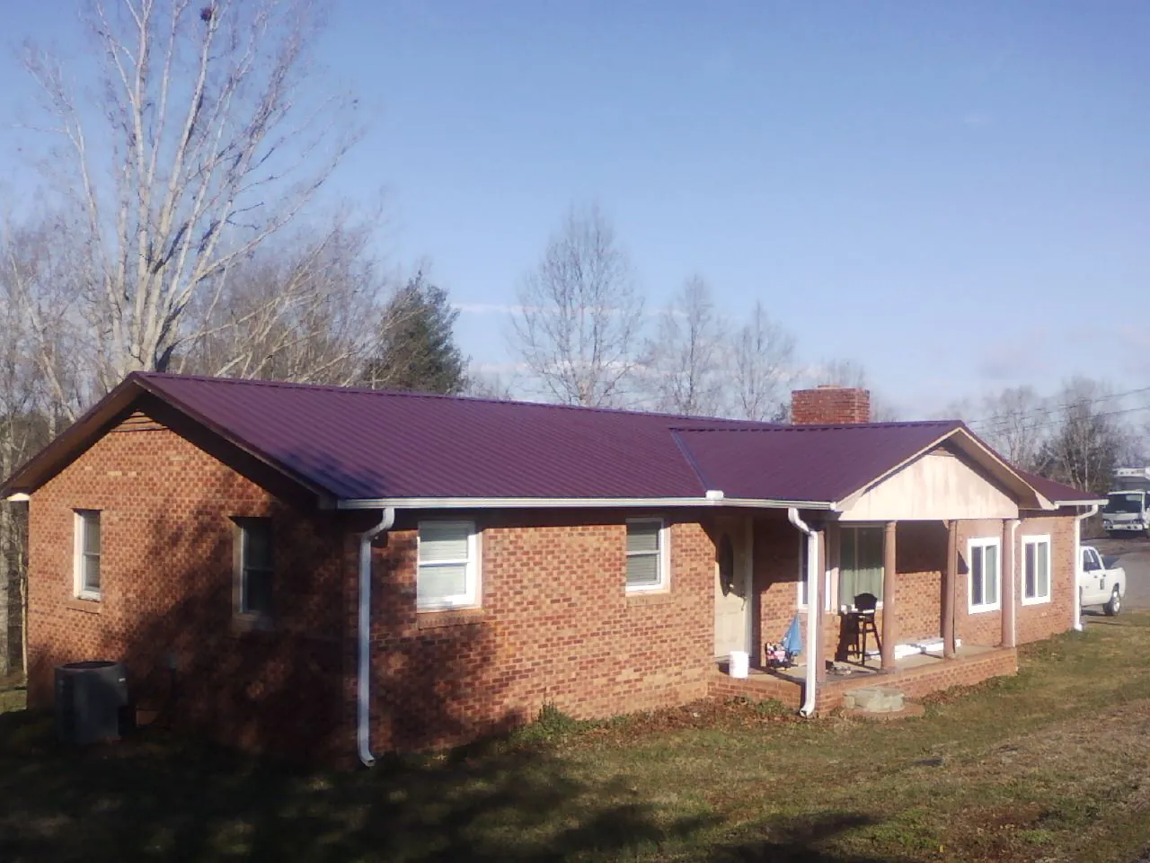 Burgundy metal roof on a brick ranch home with a new addition in Biloxi