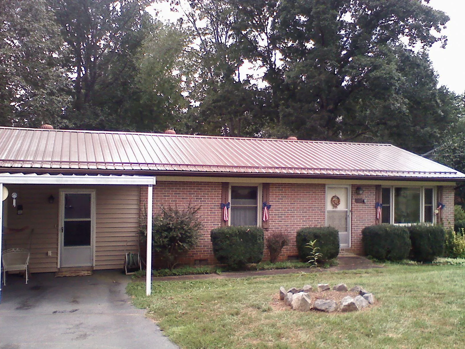 Bronze metal roof and carport on a brick ranch home — Roof Repair work by our crew in Biloxi