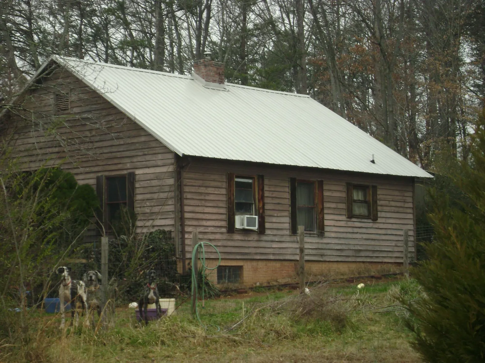 White metal roof on an old wood sided farmhouse, from a Asphalt Shingle Roof Repair job in Biloxi